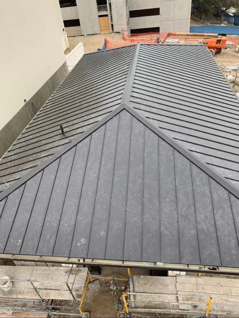 Commercial metal roof construction with crane equipment in Raytown
