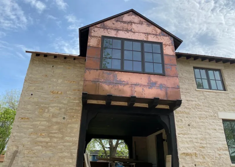 Copper metal panel facade on a stone building for Roof Repair in Raytown